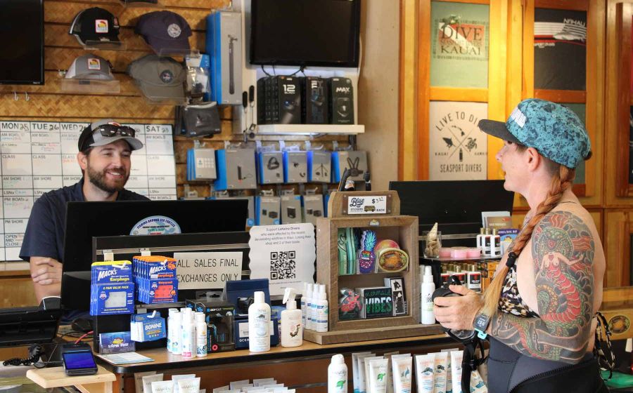 Customer at Seasport Divers dive shop getting gear ready to go on a dive in Kauai