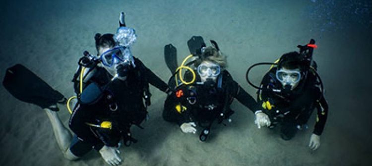 Mother father and son scuba diving from shore at Koloa Landing Kauai