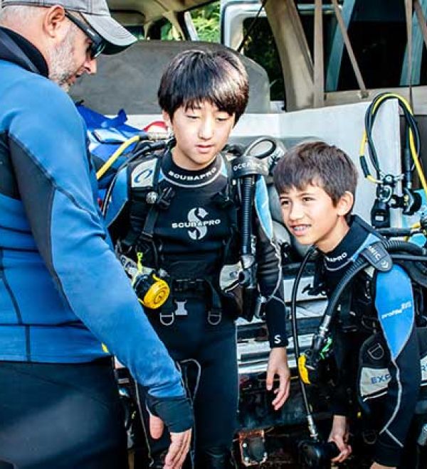 PADI Course Director teaching a scuba diving class to two kids having fun