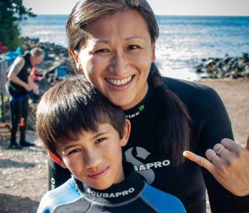 Mother hugging son after scuba diving Koloa Landing in Kauai