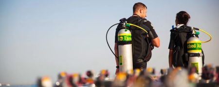 Two scuba divers ready to dive with Nitrox (Enriched Air) tanks on their back