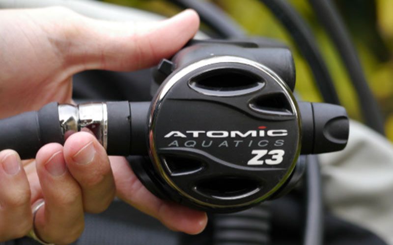 PADI instructor holding an Atomic aquatics Z3 regulator sold at Seasport Divers